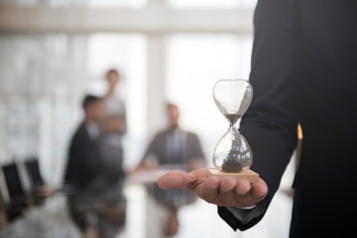 Businessman holding hour glass signifies importance being time